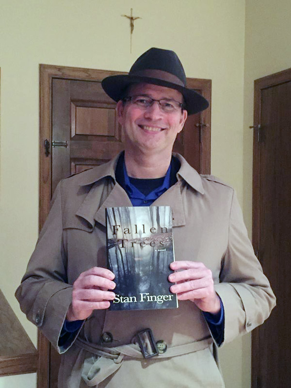 Author stan finger holding his book Fallen Trees during a Wichita book club meeting in 2017